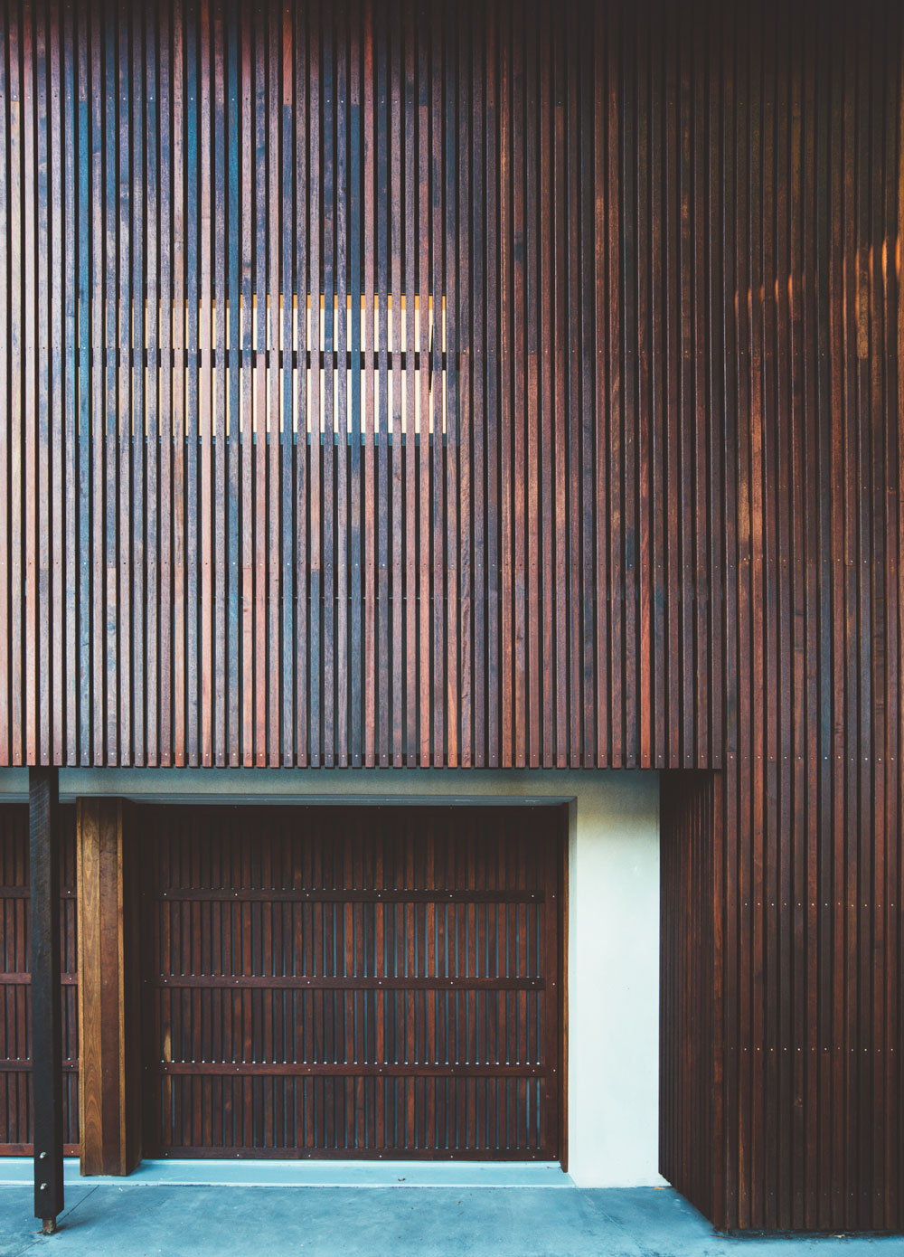 Our approach was to render the brick in a natural cement finish and design a fine timber screen that sat in front of the original facade.